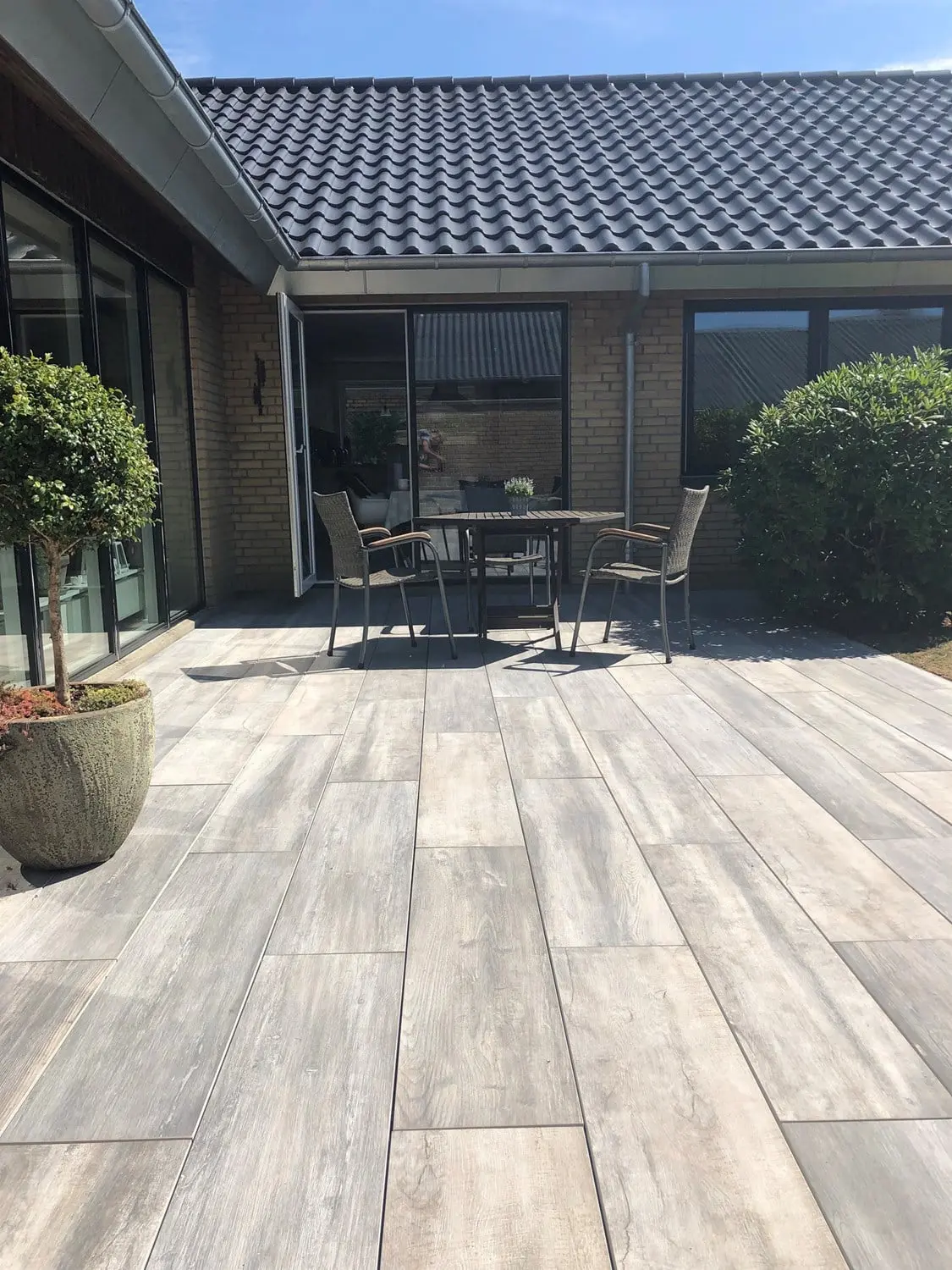 Grå fliser på en terrasse med planter